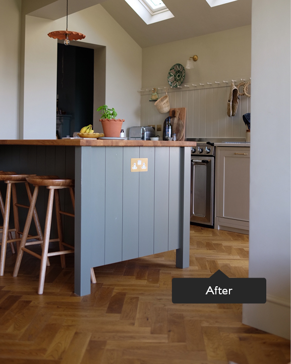 Stylish kitchen island with wooden work top and bar stools with herringbone flooring