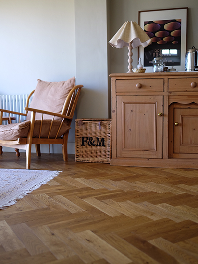 Cosy corner featuring wooden drawers, chair and herringbone flooring