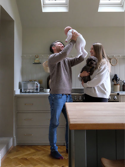 Happy dad holding baby and happy mum holding dog