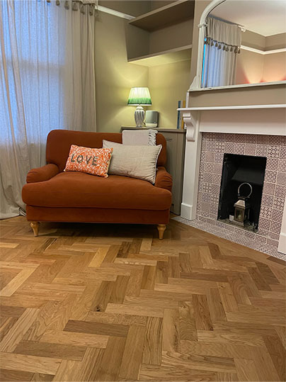 Living room with herringbone flooring and orange statement chair