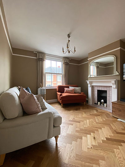 Living room with herringbone flooring and statement sofas