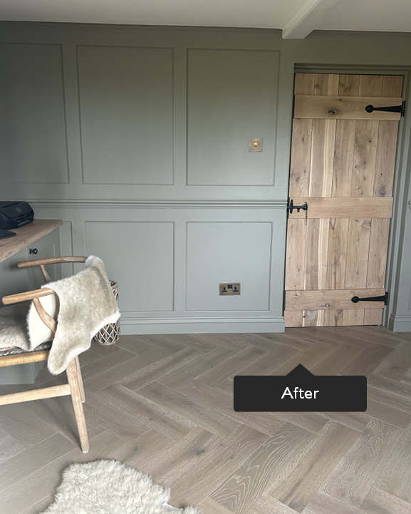 Office room with desk, sage green panelling and herringbone flooring