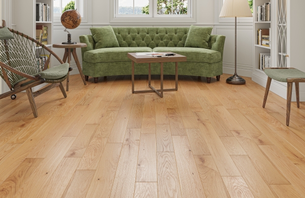 Golden oak flooring in a living room with a green sofa and white bookshelves
